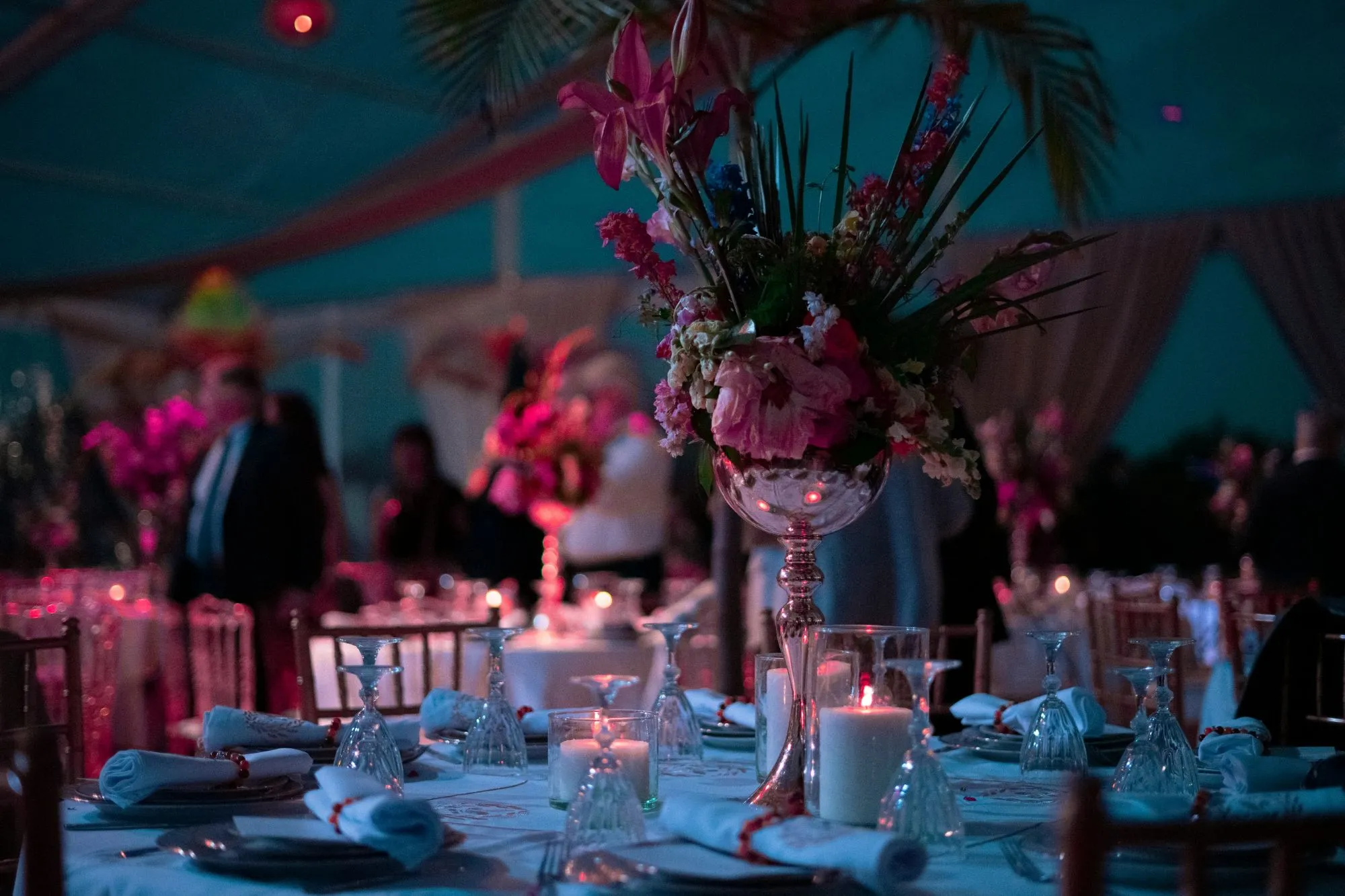 Table de réception dressée : grand bouquet sur pied argenté, bougies et verres en cristal