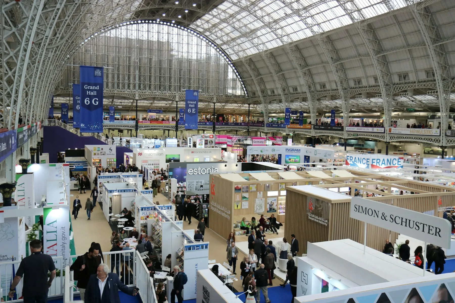 Hall d'exposition sous une grande verrière, avec de nombreux stands
